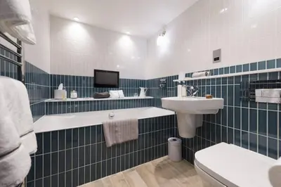 a blue and white bathroom with a sink and a toilet at The Garth 5 Star Gold Luxury Cottages in St Ives