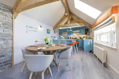 a kitchen and dining room with a wooden table and chairs at The Garth 5 Star Gold Luxury Cottages in St Ives