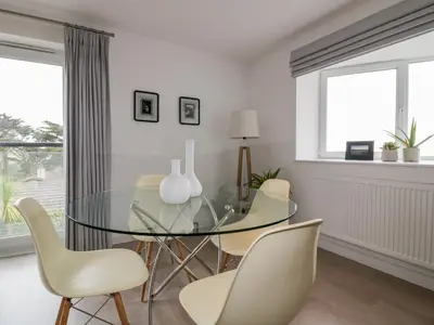 a dining room with a glass table and chairs at The Lookout in Newquay