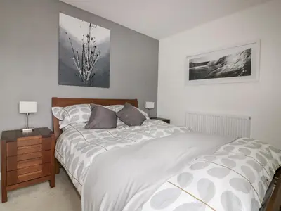 a bedroom with a bed and a night stand with two lamps at The Lookout in Newquay
