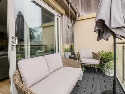 a porch with a couch and a chair at The Bolt Hole in Torpoint