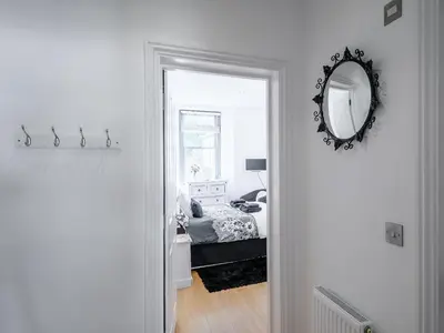 a white room with a bed and a mirror at Water View in Looe