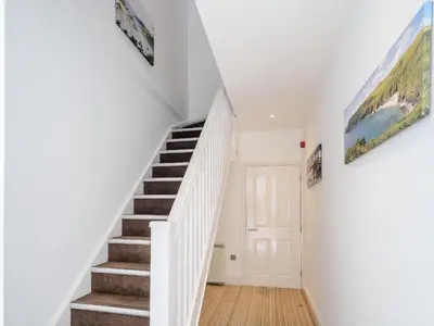 a staircase in a home with white walls and a stair case at Water View in Looe