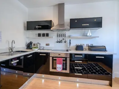 a kitchen with a stove and a counter top at Water View in Looe