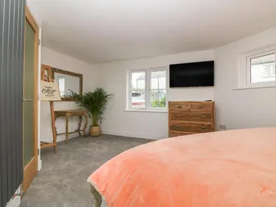 a bedroom with a bed and a flat screen tv at Fistral Bay Cottage in Newquay