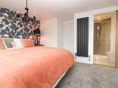 a bedroom with a large bed and a bathroom at Fistral Bay Cottage in Newquay
