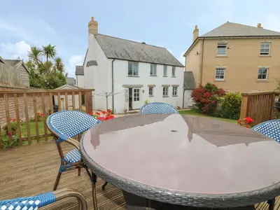 a table and chairs sitting on a deck at Fistral Bay Cottage in Newquay
