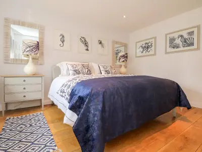 a bedroom with a bed with a blue blanket on it at Trevose House in Newquay
