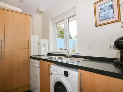a kitchen with a sink and a washing machine at Trevose House in Newquay