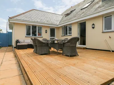 a deck with chairs and a table on a house at Trevose House in Newquay