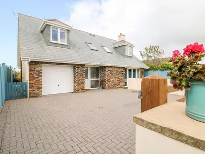 a brick house with a driveway and a garage at Trevose House in Newquay