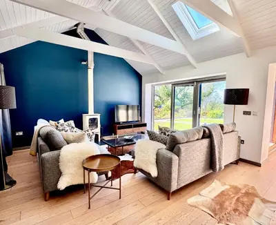 a living room with two couches and a table at Gwel an Heyl, Padstow in Little Petherick