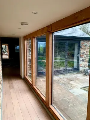 a room with three windows on a patio at Gwel an Heyl, Padstow in Little Petherick