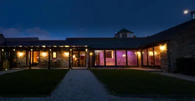 a brick building with lights on it at night at Gwel an Heyl, Padstow in Little Petherick