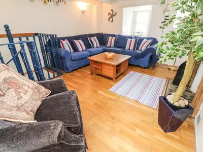 a living room with a blue couch and a table at Labour in Vain in St Ives