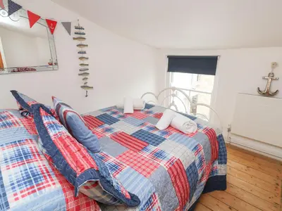 a bedroom with a bed with a plaid blanket at Labour in Vain in St Ives