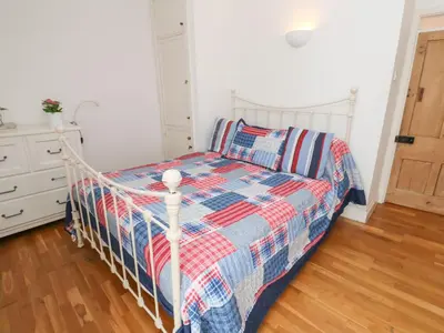 a bedroom with a bed with a checkered blanket at Labour in Vain in St Ives