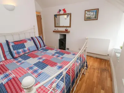 a bedroom with a bed and a mirror on the wall at Labour in Vain in St Ives