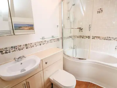 a bathroom with a sink and a tub and a toilet at Labour in Vain in St Ives