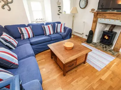 a blue couch in a living room with a fireplace at Labour in Vain in St Ives