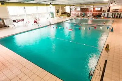 a large swimming pool with blue water in a building at Premium Chalet at Newquay Away Resorts MV7 in Newquay