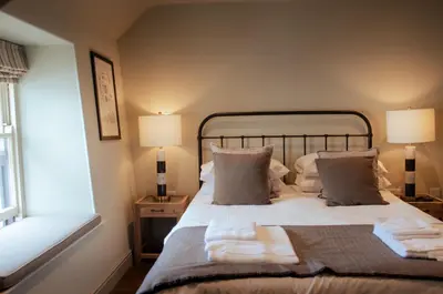 a bedroom with a bed with white sheets and pillows at Seven Stars Penryn in Penryn