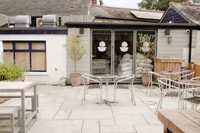 a patio with tables and chairs in front of a building at Seven Stars Penryn in Penryn