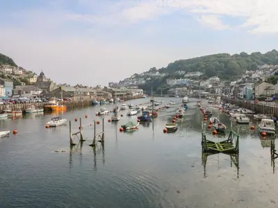 a group of boats are docked in a harbor at Pixie Cottage in Looe