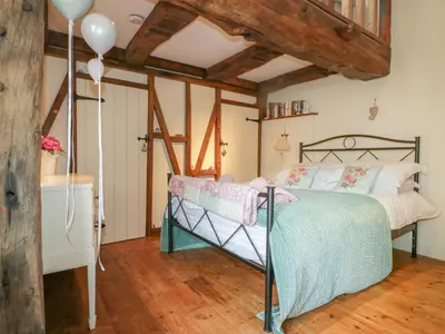 a bedroom with a bed and a wooden floor at Coinage Hall in Lostwithiel