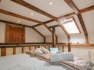 a bedroom with a large bed in a room with wooden ceilings at Coinage Hall in Lostwithiel