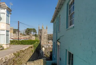 a blue building with a clock tower in the distance at The Old Smoke House in St Austell