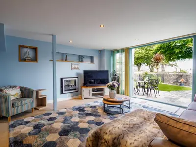 a living room with a couch and a tv at The Old Smoke House in St Austell