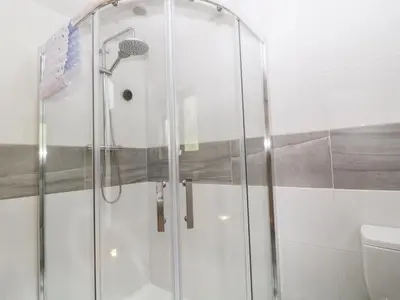 a glass shower in a bathroom with a toilet at Elvan Cottage in Liskeard