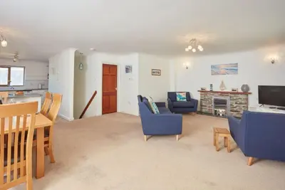 a living room with blue chairs and a fireplace at Trevells in Wadebridge