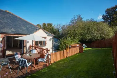 a backyard with a table and chairs and an umbrella at Trevells in Wadebridge