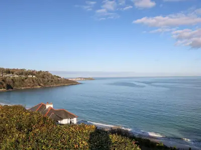a house on a hill next to a body of water at Valhalla in St Ives