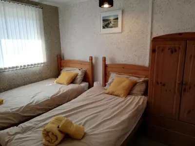 two twin beds in a bedroom with a teddy bear on them at Valhalla in St Ives