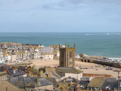 a town with a clock tower and a beach at Valhalla in St Ives