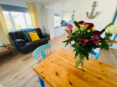 a vase of flowers on a wooden table in a living room at Driftwood Seagrass in Par