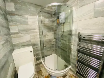 a bathroom with a glass shower and a toilet at Driftwood Seagrass in Par