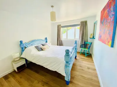 a bedroom with a blue bed and a window at Driftwood Seagrass in Par