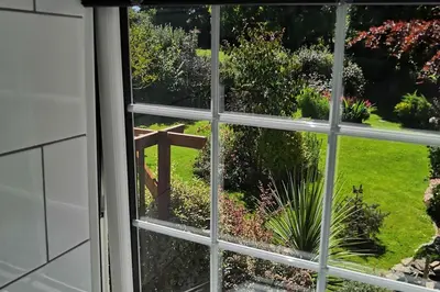 an open window looking out at a garden at 1 Bed Cottage-Sleeps 3-Pool-Pets-near St Ives in Camborne
