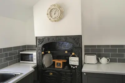 a kitchen with a clock on the wall at 1 Bed Cottage-Sleeps 3-Pool-Pets-near St Ives in Camborne