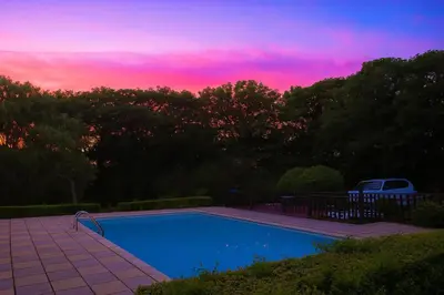 a swimming pool with a sunset in the background at 1 Bed Cottage-Sleeps 3-Pool-Pets-near St Ives in Camborne