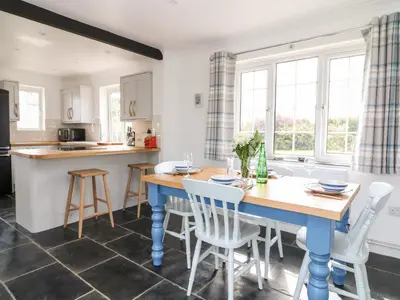 a kitchen and dining room with a blue table and chairs at Summercourt in Launceston
