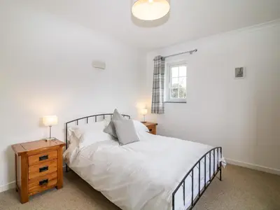 a bedroom with a white bed and a window at Summercourt in Launceston