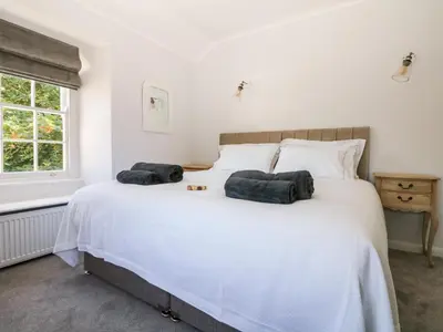 a bedroom with a large white bed with two pillows at Culdrose Manor in Helston