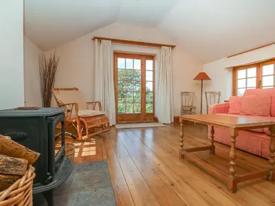 a living room with a couch and a table at Higher Roskorwell Cottage in Helston