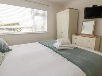 a bedroom with a bed with towels on it at 2 Europa Court in Newquay