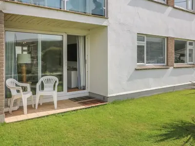 a patio with two chairs and a table at 2 Europa Court in Newquay